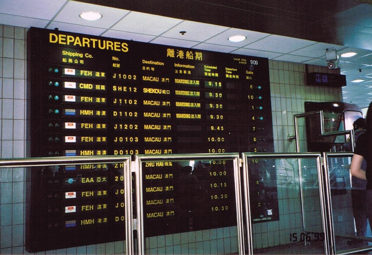 Historical photograph of a split-flap departure board in service at a Macau ferry terminal